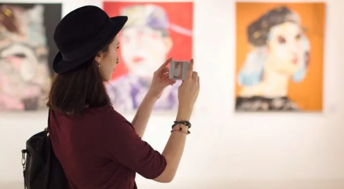 Woman taking photos in art gallery