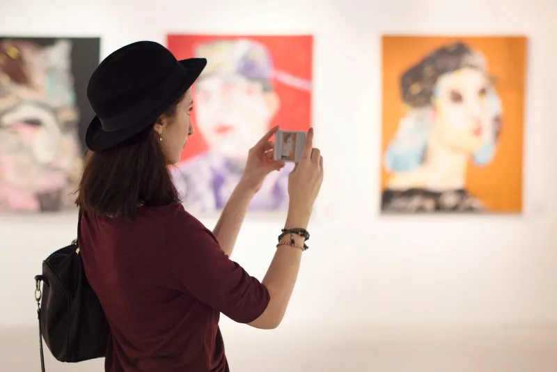 Woman taking photos in art gallery