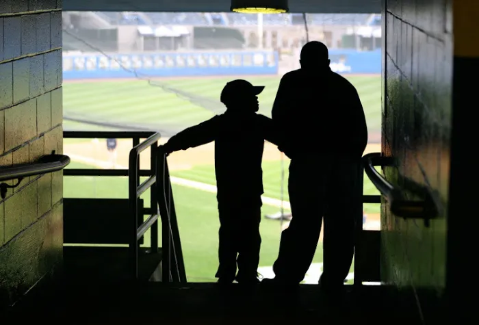 a father and son attend a baseball game