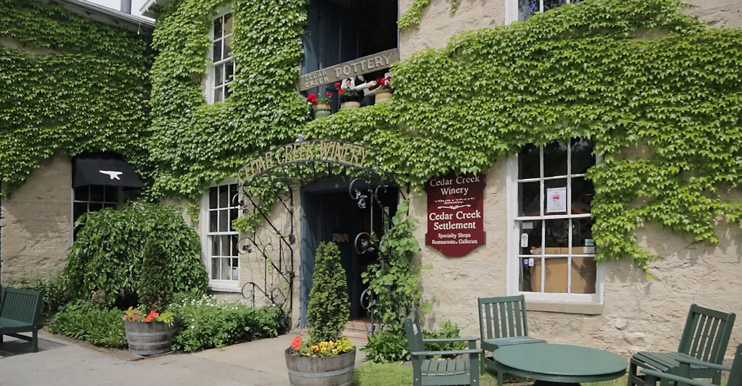 the exterior of the Cedar Creek Winery with vines surrounding the entrance