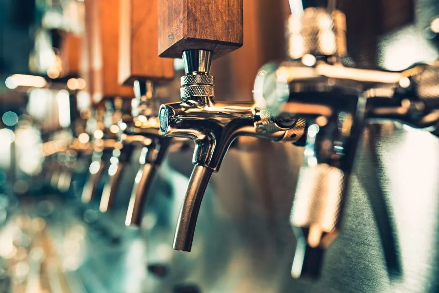 a row of beer taps at a bar