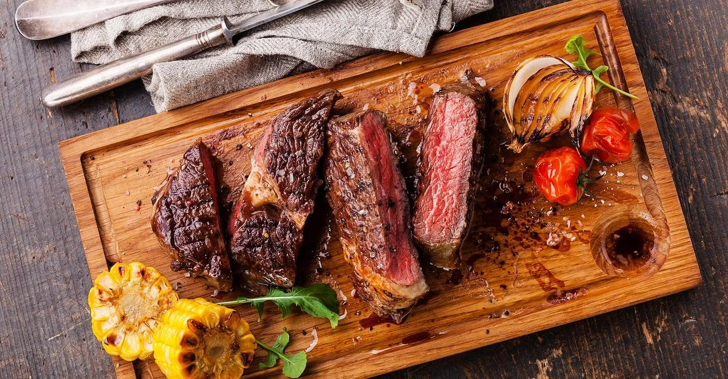 a wooden slider with steak