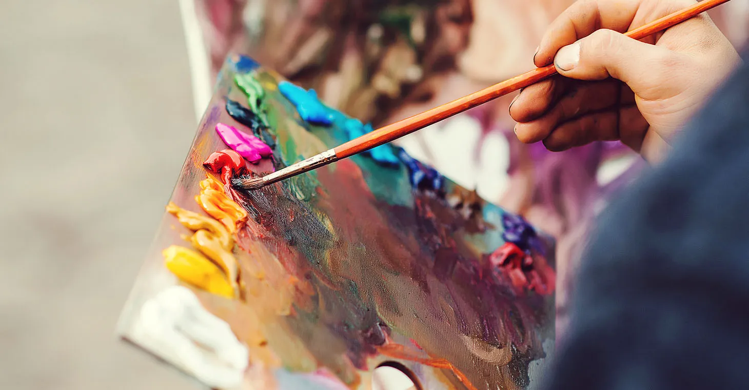 Artist working with paint on a palette