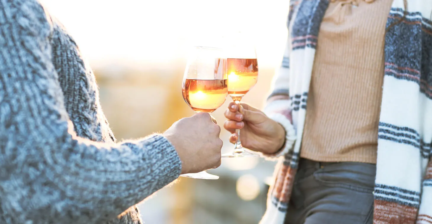 Two women holding a glass of rose wine outside