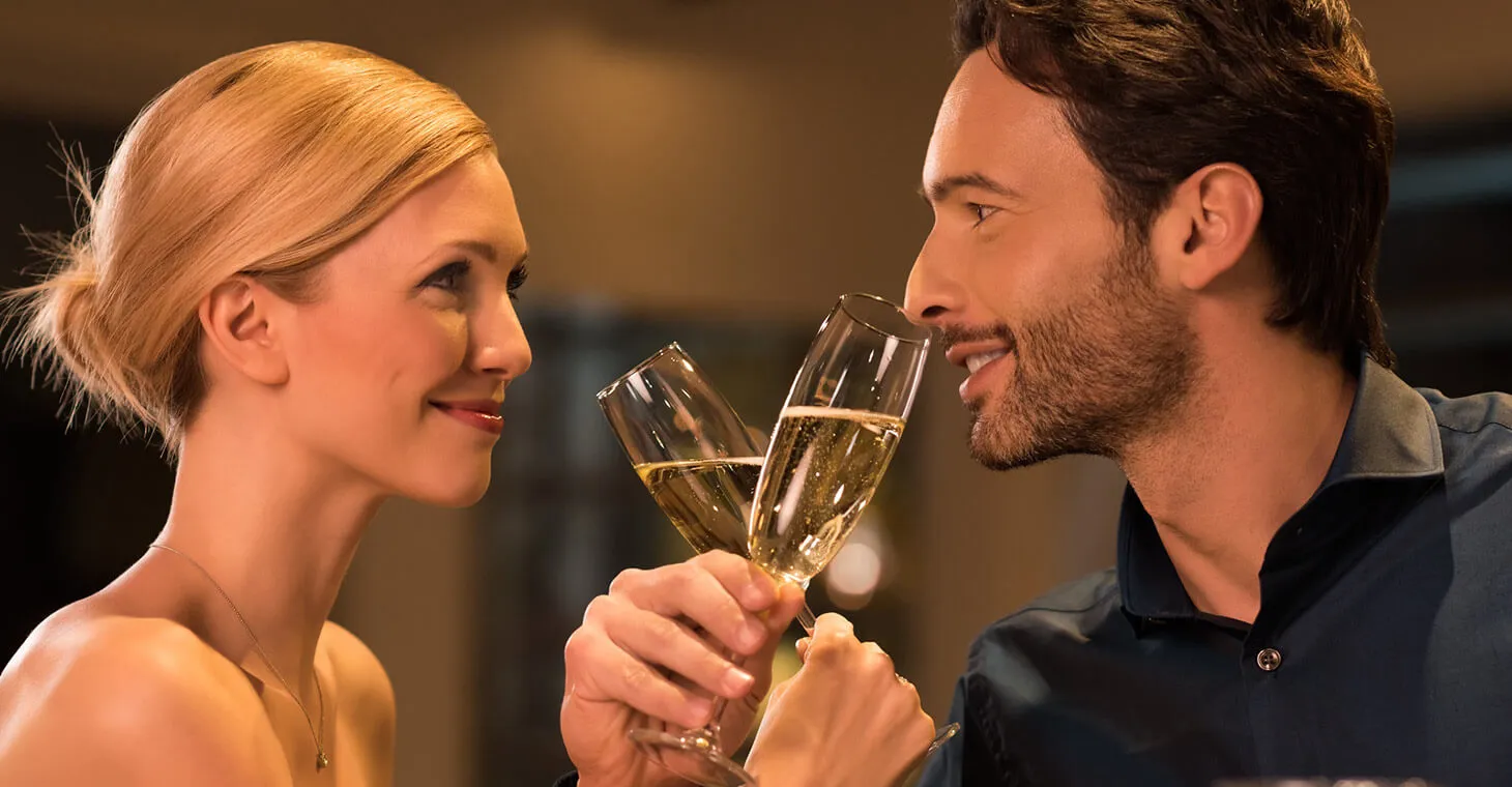 a man and woman at a romantic dinner with Champagne