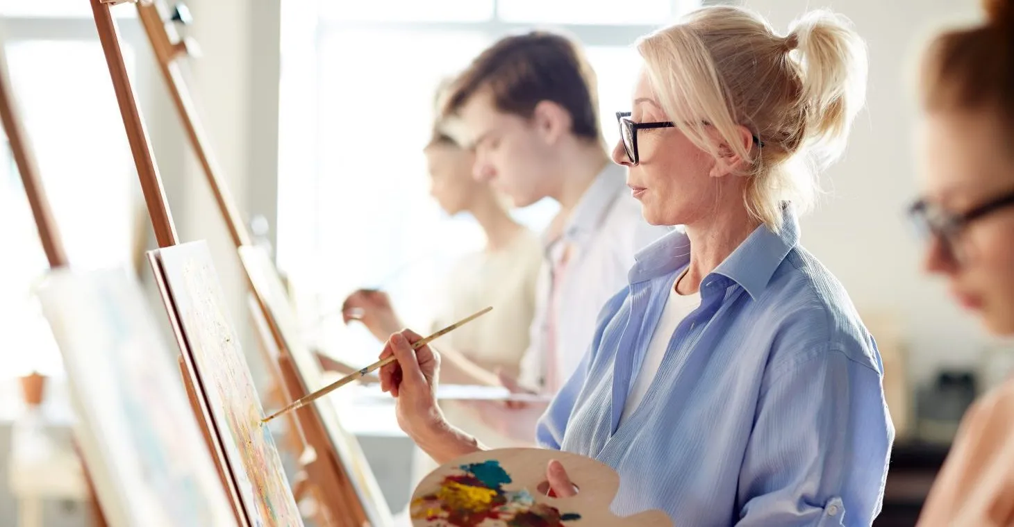 a woman painting in a class
