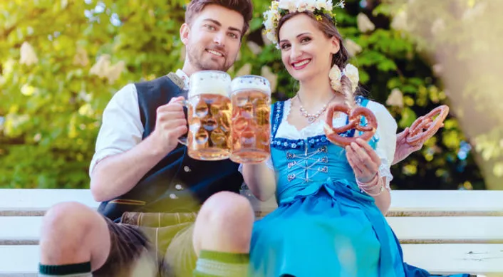 couple at Cedarburg Oktoberfest on a bench with beers