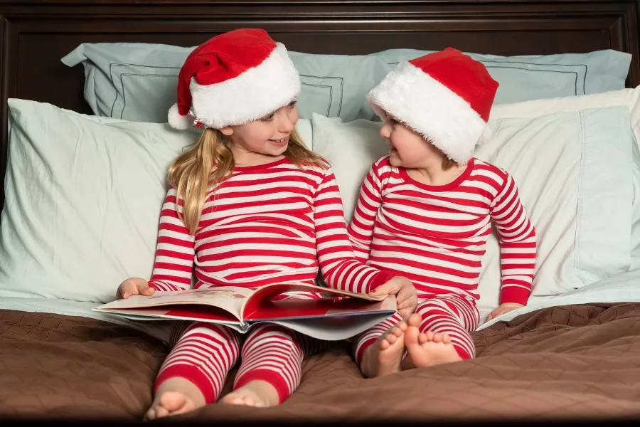 Kids reading a Christmas book in matching pajamas