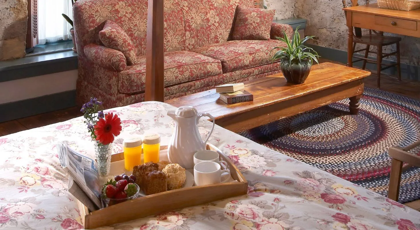 Tray of breakfast food and orange juice on a bed at Washington House Inn