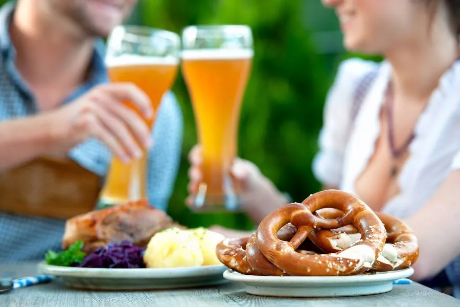 Pretzels, bratwurst, and other traditional German food and drinks at a festival.