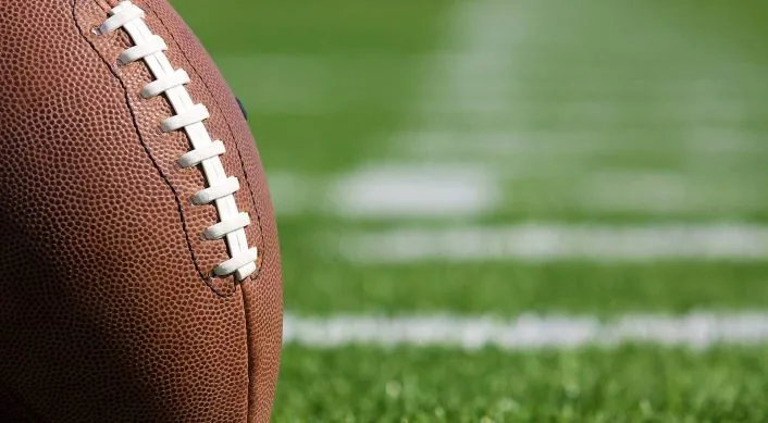 American football sitting on an empty field