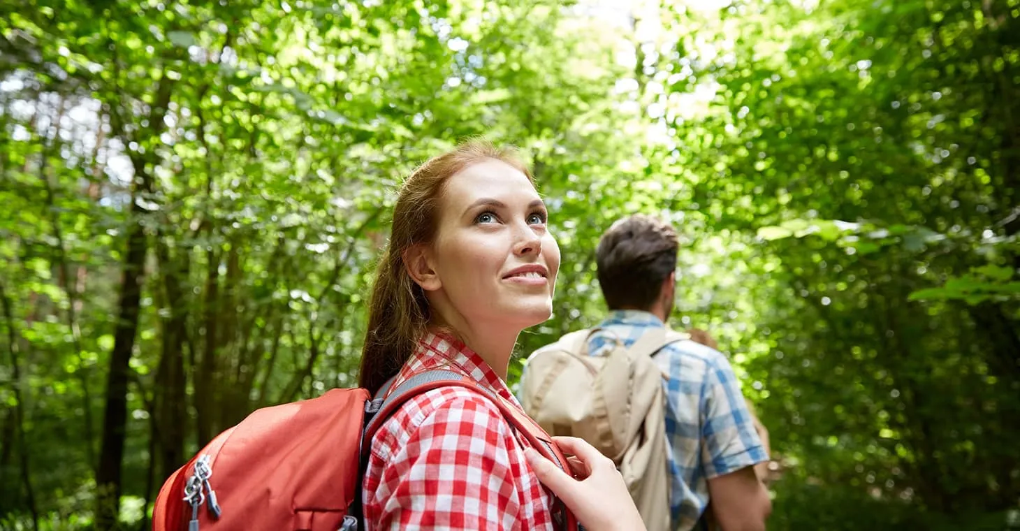 romantic couple hiking through green trees