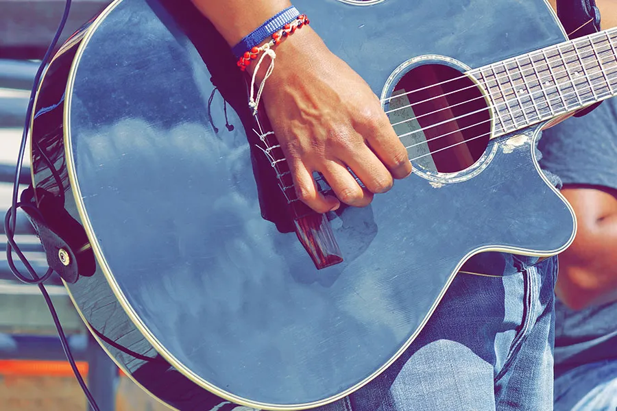 a man playing a guitar at an outdoor music festival in Wisconsin