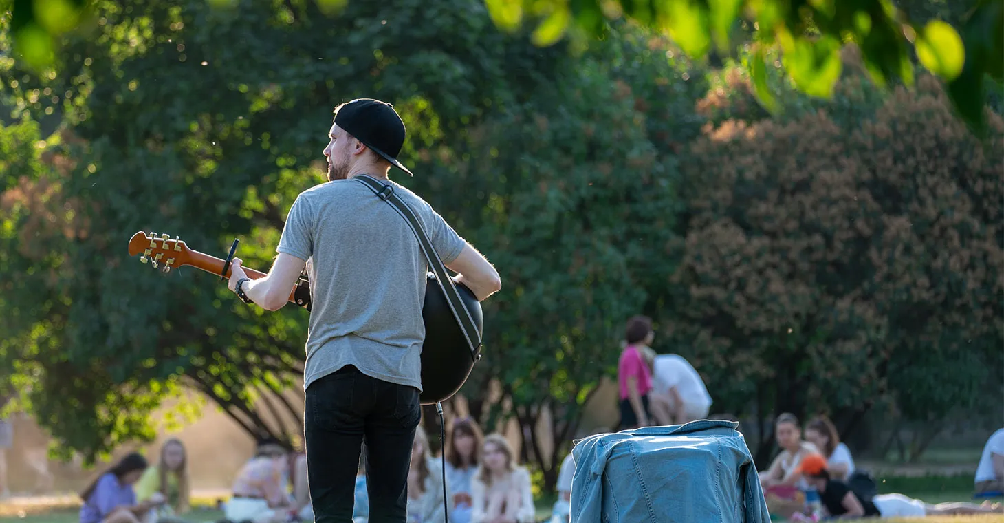 Musician playing guitar in a park