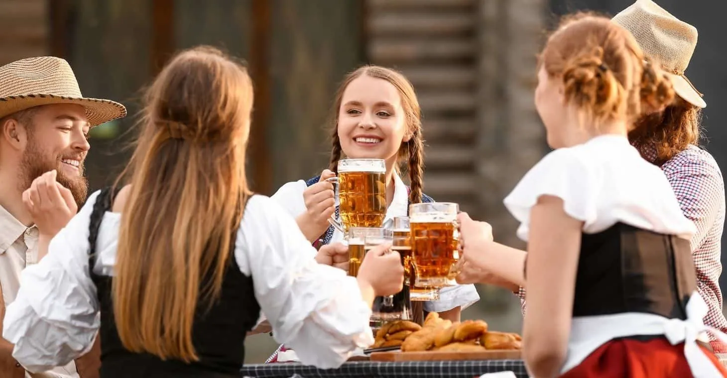 Friends enjoying traditional German food, beer, and festive atmosphere at Cedarburg Oktoberfest