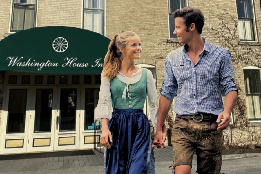 Couple dressed in Bavarian clothes standing in front of Washington House Inn